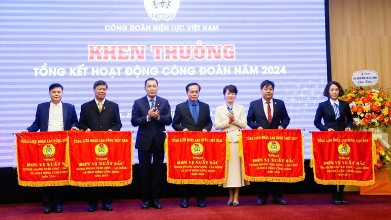 Bà Trần Thị Thanh Hà, Trưởng ban Quan hệ lao động Tổng Liên đoàn Lao động Việt Nam và Chủ tịch Hội đồng thành viên EVN Đặng Hoàng An trao Cờ thi đua của Tổng Liên đoàn Lao động Việt Nam tặng các tập thể.
