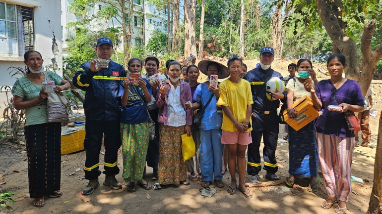 Người dân được các cán bộ, chiến sĩ Bộ Công an Việt Nam cứu trợ thực phẩm.