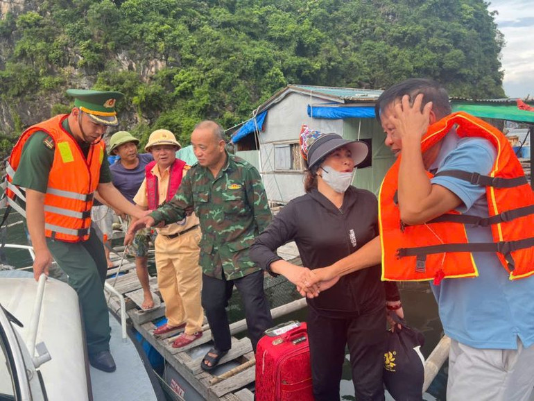 Cán bộ Đồn Biên phòng Trà Cổ (Bộ đội Biên phòng tỉnh Quảng Ninh phối hợp lực lượng Công an hỗ trợ người dân di chuyển đến nơi an toàn.