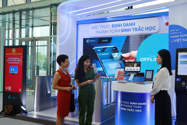 Đại diện Trung tâm Dữ liệu quốc gia về dân cư (C06) giới thiệu với khách tham quan thông tin về xác thực định danh và thanh toán sinh trắc học.