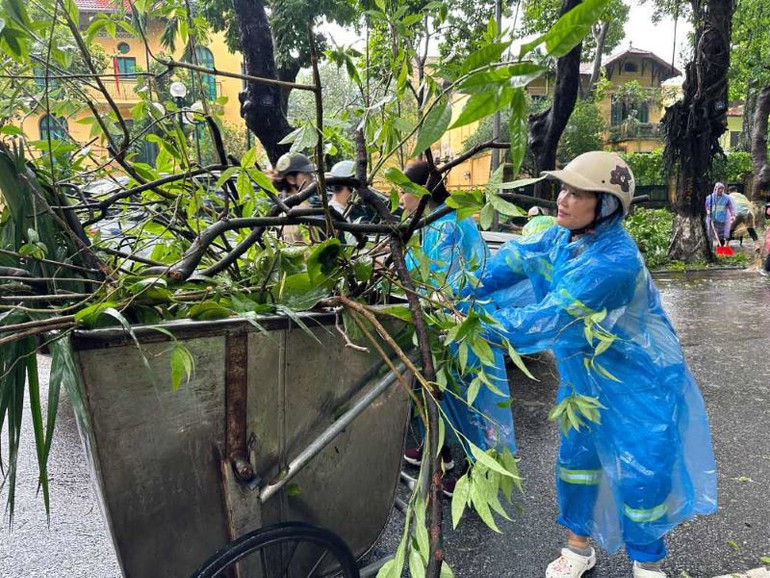 Công nhân Công ty TNHH MTV Môi trường đô thị Hà Nội dọn cành, lá cây trên phố Phan Đình Phùng