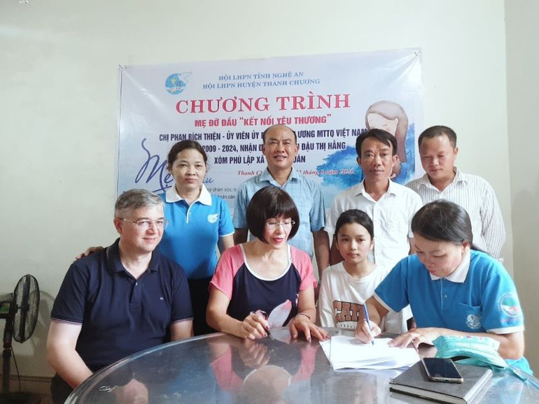 Mẹ đỡ đầu Phan Bích Thiện nhận đỡ đầu con nuôi Đậu Thị Hằng dưới sự chứng kiến của Hội phụ nữ và chính quyền địa phương. Mẹ đỡ đầu Phan Bích Thiện nhận đỡ đầu con nuôi Đậu Thị Hằng dưới sự chứng kiến của Hội phụ nữ và chính quyền địa phương.