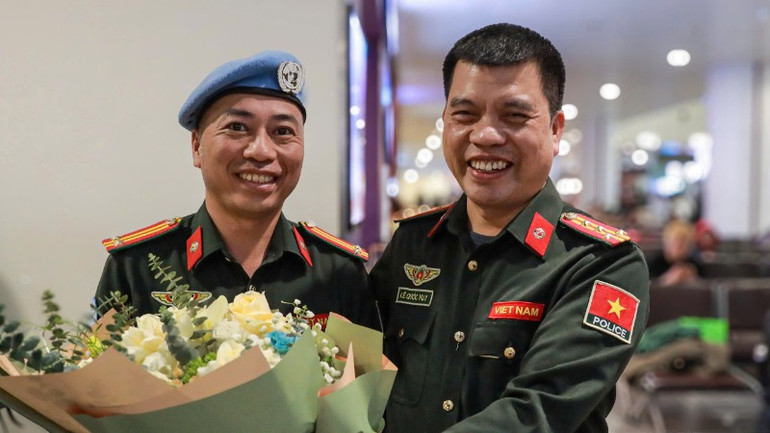 Trung tá Bùi Phương Lân nhận bó hoa tươi thắm từ đồng đội.