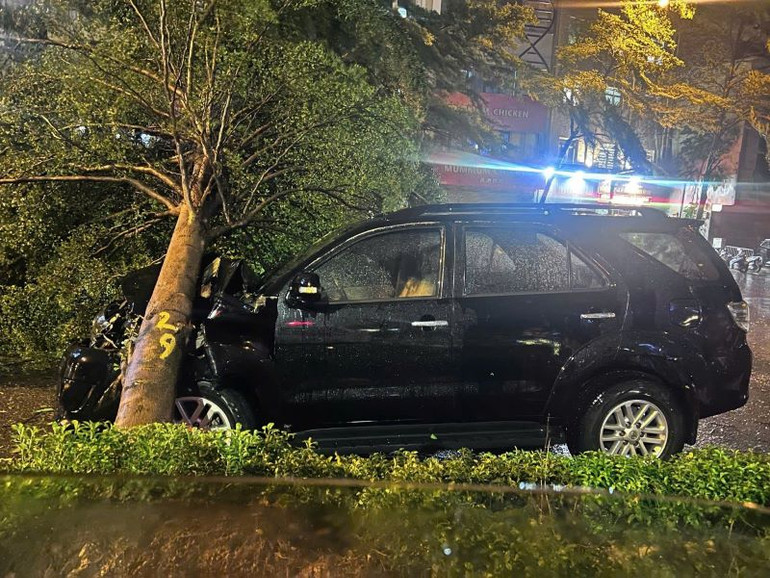 Chiếc xe ô tô bị cây đổ đè vào khiến người điều khiển bị mắc kẹt và choáng ngất.