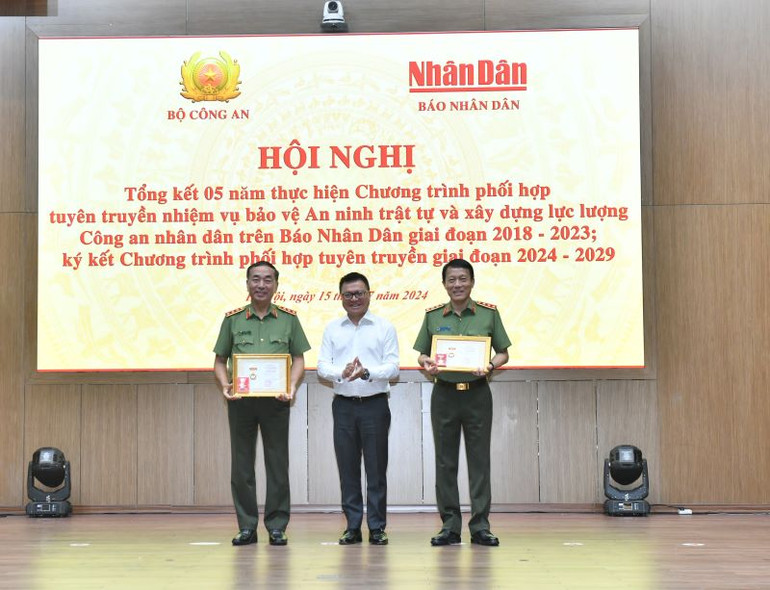 Tổng Biên tập Báo Nhân Dân Lê Quốc Minh trao Kỷ niệm chương "Vì sự nghiệp Báo Nhân Dân" tặng Bộ trưởng Công an Lương Tam Quang và Thứ trưởng Công an Trần Quốc Tỏ.