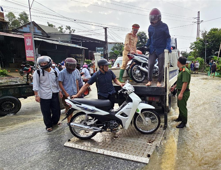 Cảnh sát giao thông Tuyên Quang dùng xe chuyên dụng giúp nhân dân di chuyển qua những đoạn úng ngập.