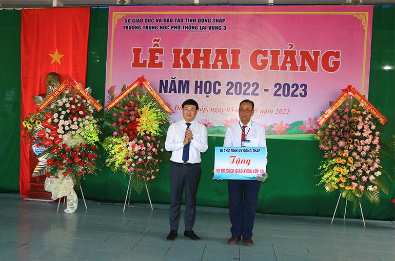 Bí thư Tỉnh ủy Đồng Tháp Lê Quốc Phong trao bảng tượng trưng tặng 50 bộ sách lớp 10 hỗ trợ học sinh khó khăn.