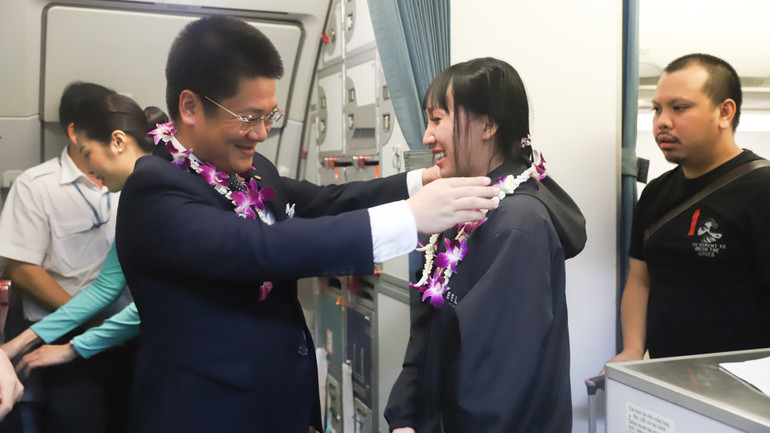 Trưởng Chi nhánh Vietnam Airlines tại Thái Lan Đào Trường Lưu tặng hoa cho hành khách trên chuyến bay.