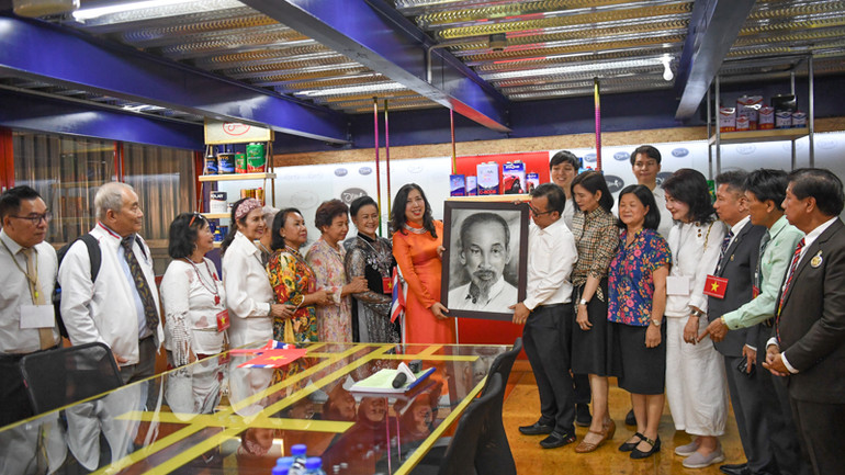 Ông Bùi Văn Sĩ, Giám đốc Công ty Plan Paint trao bức tranh chân dung Bác Hồ do ông tự vẽ tặng Thứ trưởng Lê Thị Thu Hằng. (Ảnh: XUÂN SƠN)