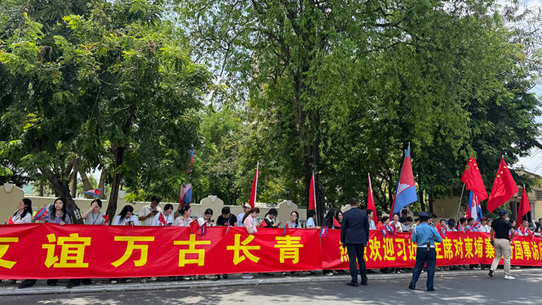 Người dân Phnom Penh cầm cờ và biểu ngữ chào đón Tổng Bí thư, Chủ tịch Trung Quốc Tập Cận Bình. (Ảnh: ĐINH TRƯỜNG)