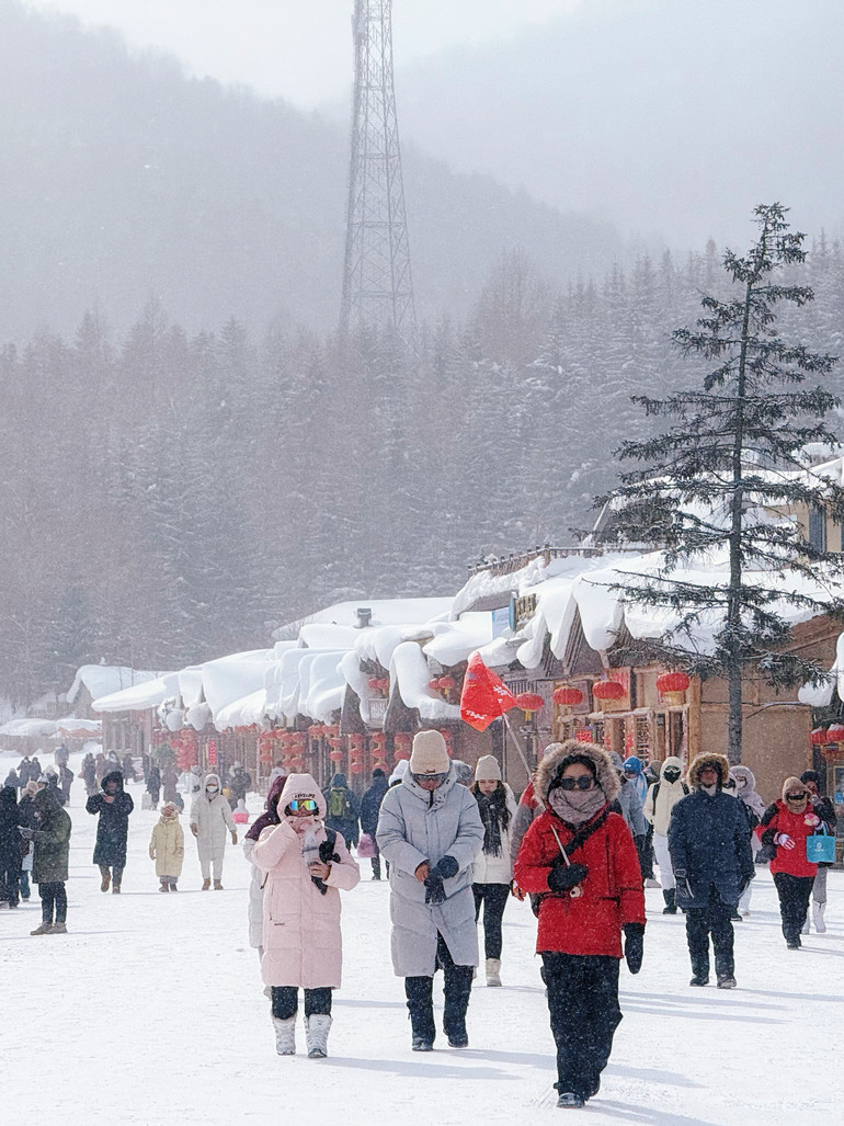 Một hướng dẫn viên và khách du lịch trong những bộ trang phục "đại hàn" đi giữa Làng Tuyết.