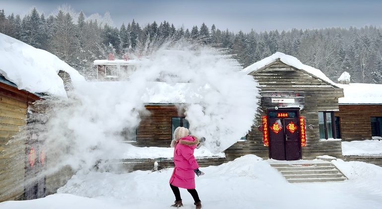 Một du khách thích thú với trò tung nước tạo tuyết giữa thời tiết băng giá.