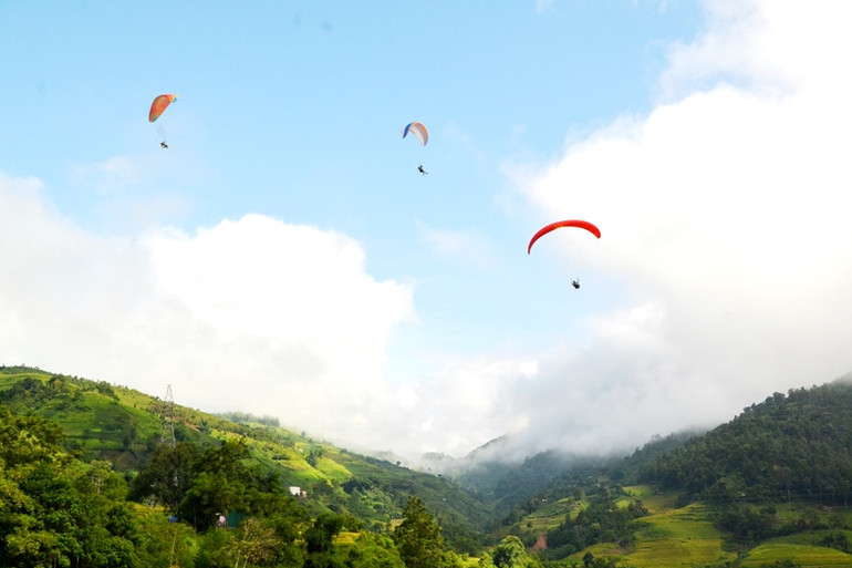 Các vận động viên chuyên nghiệp và du khách trải nghiệm bay dù lượn trên thung lũng Mường Hum (Bát Xát- Lào Cai), với đường bay dài hơn 2km. (Ảnh: QUỐC HỒNG)