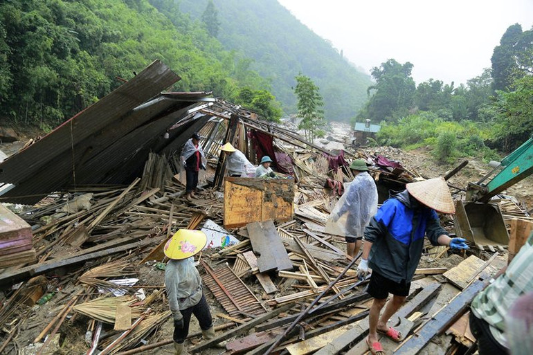 Người dân các xã lân cận đến hỗ trợ, giúp đồng bào thôn Nậm Than khắc phục hậu quả lũ ống. (Ảnh: QUỐC HỒNG)