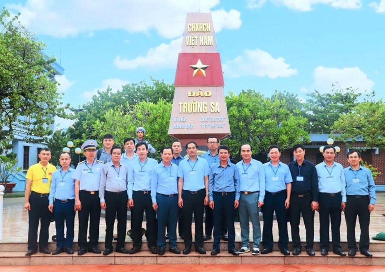 Đoàn công tác của tỉnh Lào Cai chụp ảnh bên cột mốc chủ quyền tại đảo Trường Sa, tháng 5/2023.