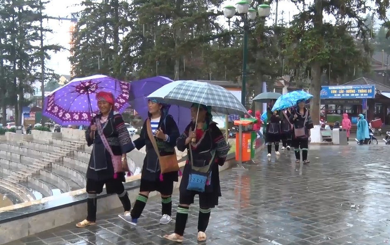 Người dân Sa Pa sau cơn mưa. (Ảnh: QUỐC HỒNG)