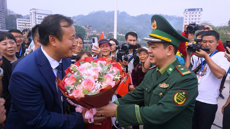 Tặng hoa chúc mừng sự kiện nối lại hoạt động du lịch lữ hành Việt Nam-Trung Quốc tại cầu Hồ Kiều. (Ảnh: QUỐC HỒNG)
