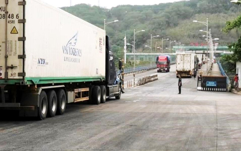 Lực lượng Biên phòng điều tiết, phân luồng xe xuất, nhập khẩu hàng hóa qua cầu đường bộ Kim Thành. (Ảnh: TRUNG DŨNG)