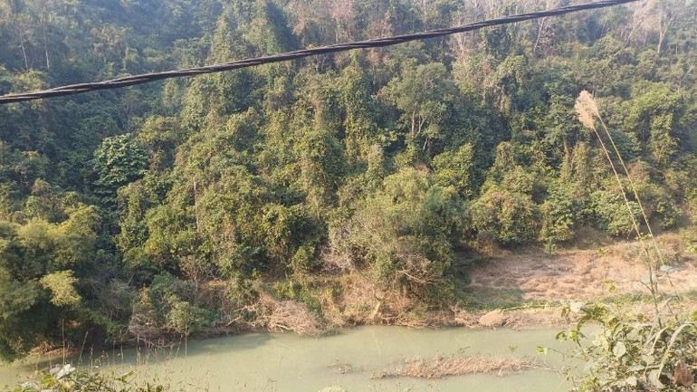 Đoạn sông Hiến phía sau chỗ diễn ra hoạt động khai thác khoáng sản, nước sông chuyển sang màu xám đục.