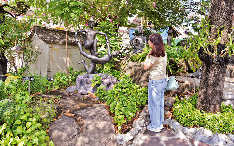 Du khách chiêm ngưỡng những bức tượng cổ về massage Thái trong chùa Wat Pho.