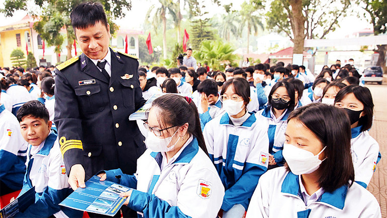 Cán bộ Lữ đoàn đặc công Hải quân 126 phát tờ rơi, tuyên truyền đến học sinh Trường THPT Lạng Giang số 1. (Ảnh Quốc Phương)