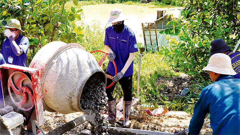 Các chiến sĩ tình nguyện Mùa hè xanh tham gia làm đường nông thôn.