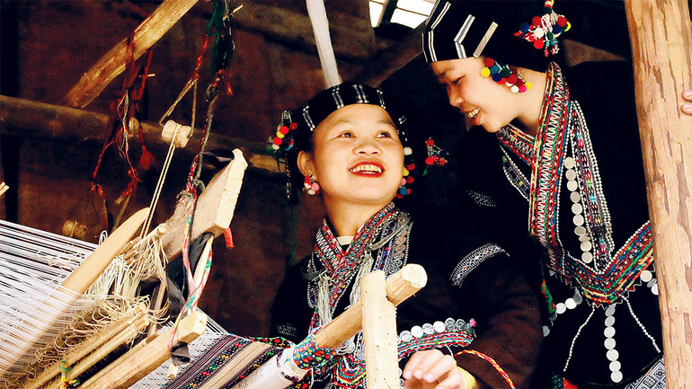 Phụ nữ dân tộc Lự bên khung cửi.