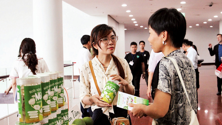 Các đại biểu tìm hiểu, sử dụng sản phẩm khởi nghiệp.(Ảnh Thanh Tâm)