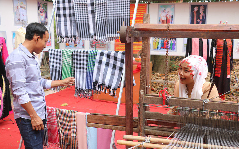 Khách tham quan tìm hiểu các sản phẩm dệt của một cơ sở dệt thổ cẩm làng Chăm, xã Tân Châu, tỉnh An Giang trưng bày tại tỉnh Trà Vinh. (Ảnh MINH KHỞI)