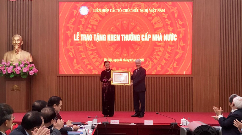 Đồng chí Đỗ Văn Chiến trao Huân chương Độc lập hạng Ba tặng bà Nguyễn Phương Nga.