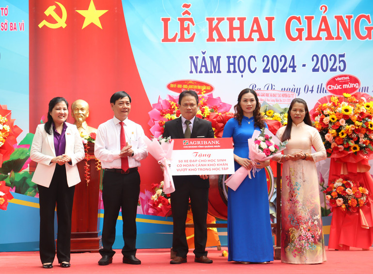 Đại diện lãnh đạo Agribank- Chi nhánh Quảng Ngãi trao biểu trưng tặng 50 chiếc xe đạp cho các em học sinh có hoàn cảnh khó khăn, vượt khó trong học tập của Trường trung học cơ sở Ba Vì.