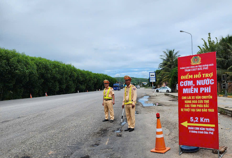 Cán bộ, chiến sĩ Trạm Cảnh sát giao thông Đức Phổ luôn túc trực tại biển hướng dẫn đặt tại trạm để hướng dẫn những chuyến xe nghĩa tình di chuyển đến điểm hỗ trợ cơm, nước miễn phí.