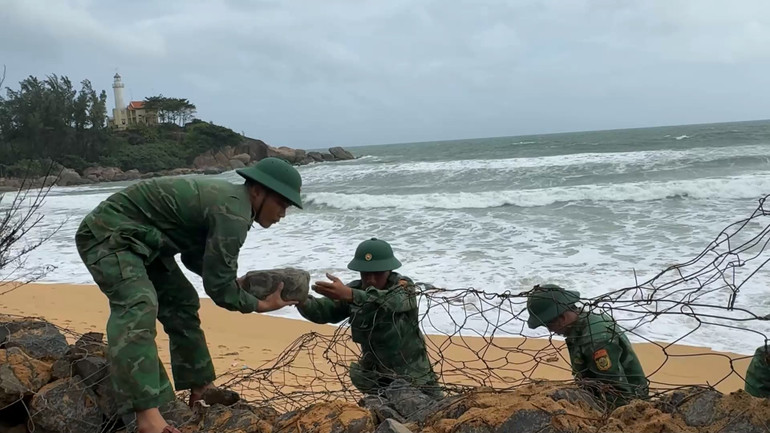 Cán bộ, chiến sĩ Đồn Biên phòng cửa khẩu cảng Dung Quất khắc phục tạm thời sạt lở bằng kè đá.