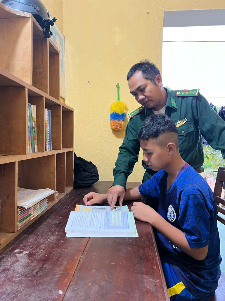 Cán bộ Ðồn Biên phòng Mo Rai hướng dẫn A Ứng học bài. Cán bộ Ðồn Biên phòng Mo Rai hướng dẫn A Ứng học bài.