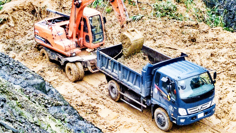 Lực lượng chức năng khắc phục điểm sạt lở tại đèo So trên Quốc lộ 3C. (Ảnh THẾ BÌNH)