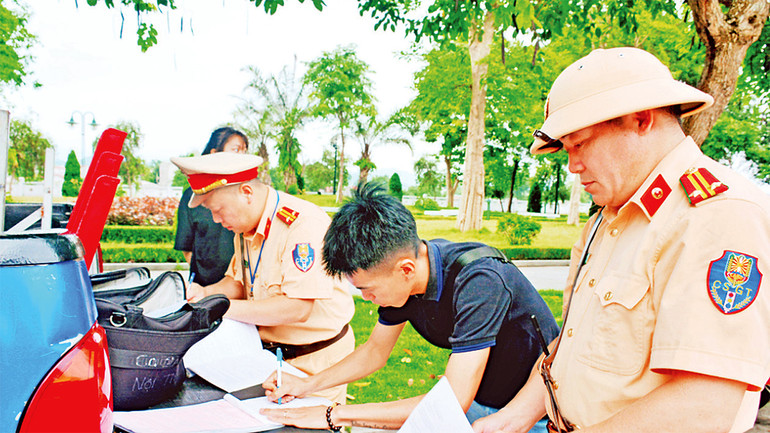 Lực lượng cảnh sát giao thông-trật tự thành phố Lạng Sơn lập biên bản học sinh vi phạm quy định về an toàn giao thông. (Ảnh Hoàng Cường)