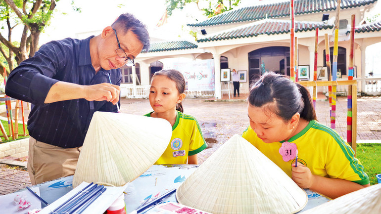 Trải nghiệm, vẽ tranh sen trên nón lá.