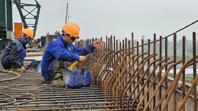 Công nhân thi công cầu Nam Khê trên tuyến đường bộ ven biển qua huyện Hậu Lộc, tỉnh Thanh Hóa. (Ảnh: MAI LUẬN)