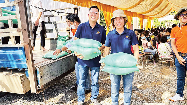 Chị Nhung cùng nhân viên chuyển gạo tặng người nghèo. Chị Nhung cùng nhân viên chuyển gạo tặng người nghèo.