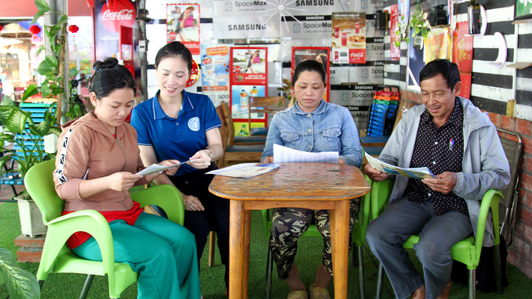 Cán bộ Bảo hiểm xã hội tỉnh tư vấn cho gia đình chị Lê Hoàng Dung tham gia bảo hiểm xã hội tự nguyện.
