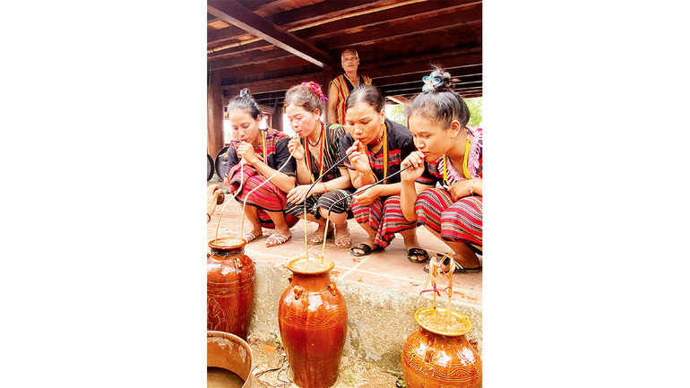 Dân làng thưởng thức rượu thiêng để mong thần linh chứng giám, phù hộ gia đình mình.