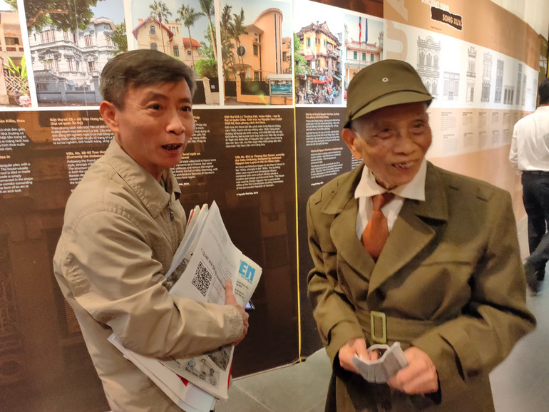 Ông Phạm Văn Nghĩa (phải), 97 tuổi, được con trai đưa đi Hội Báo cho biết, ông thường tham quan các Hội Báo. Theo ông, Hội Báo năm nay tổ chức chu đáo hơn và quy mô lớn hơn so với các năm trước. Ông cho biết, ông thường mang báo từ Hội Báo về để phát cho mọi người trong tổ dân phố và mọi người đón đọc rất hào hứng.