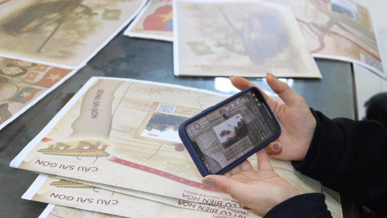 Các bạn trẻ ở Quảng Ngãi rất thích thú tìm hiểu lịch sử vẻ vang của dân tộc thông qua các mã QR in trên phụ san đặc biệt của Báo Nhân Dân.