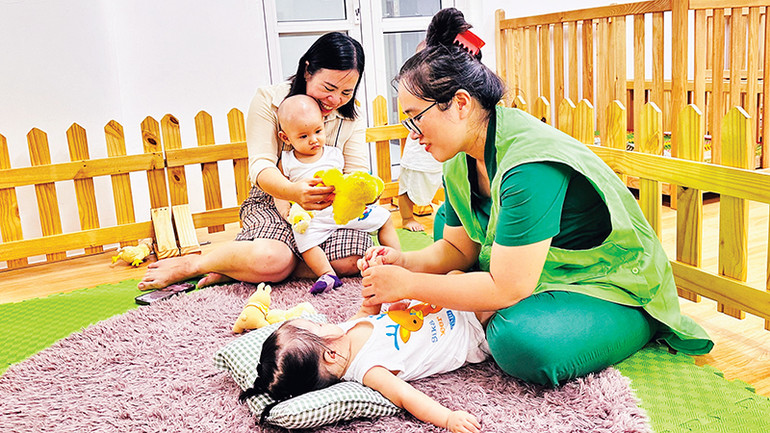 Cô giáo massage cho bé tại nhóm lớp 6 -12 tháng tuổi.