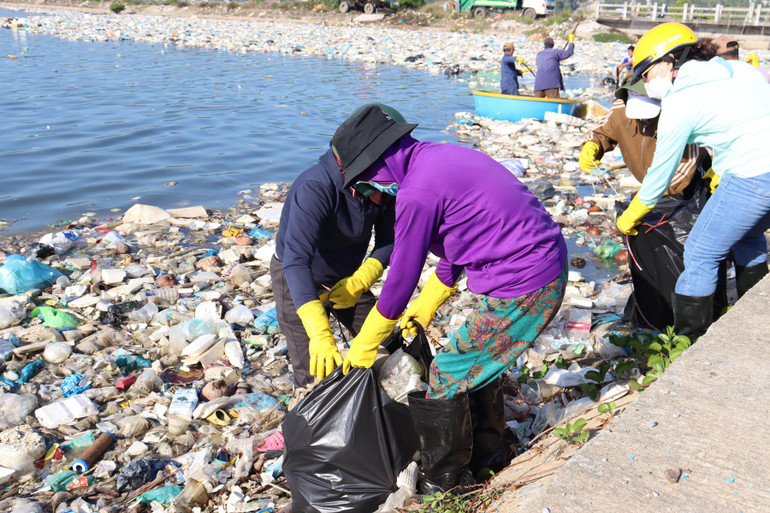 Rác thải được vớt lên cho vào bao chuyển lên xe môi trường đưa đi xử lý.
