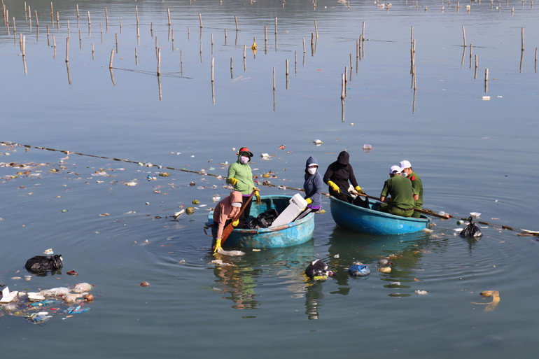 Người dân dùng thuyền thúng để vớt rác trên mặt nước.