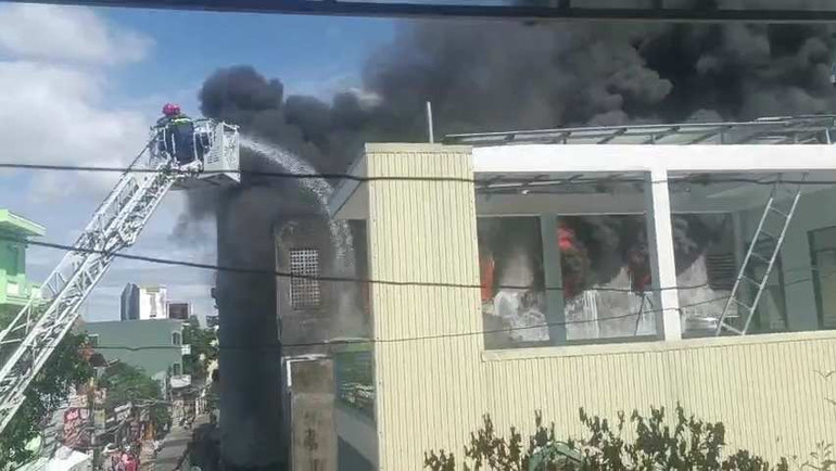 Lực lượng Cảnh sát phòng cháy chữa cháy sử dụng xe thang chữa cháy phun nước từ trên cao để ngăn ngọn lửa cháy lan sang các nhà dân liền kề.