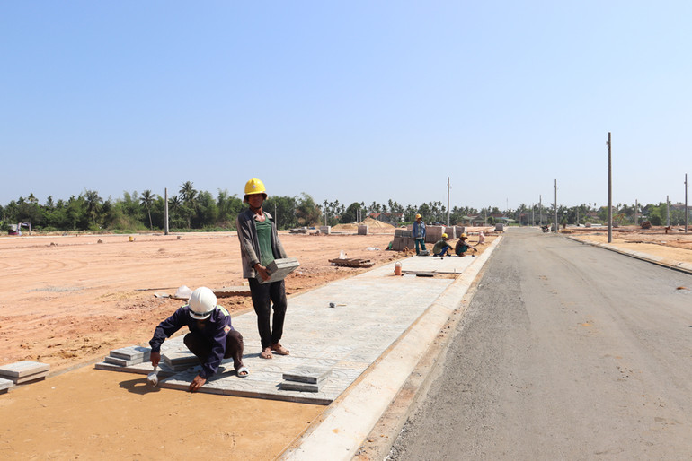 Công nhân lát vỉa hè dự án Khu tái định cư Đồng Giá, huyện Nghĩa Hành.