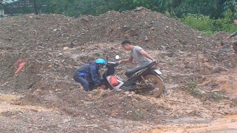 Người dân khó nhọc, nỗ lực đưa xe máy qua vị trí đường tắc.