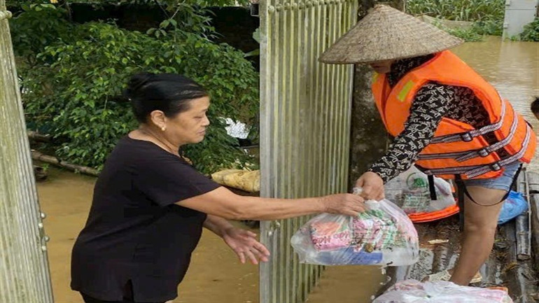 Tình nguyện viên hỗ trợ thực phẩm cho gia đình bị ngập lụt.